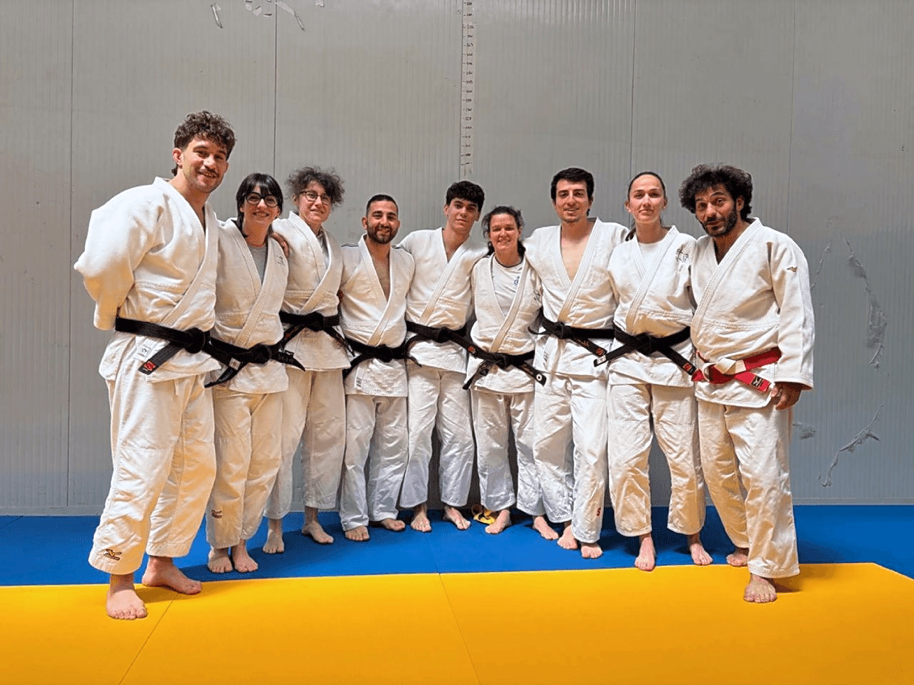 Gli istruttori e le istruttrici con la cintura nera in posa sul tatami