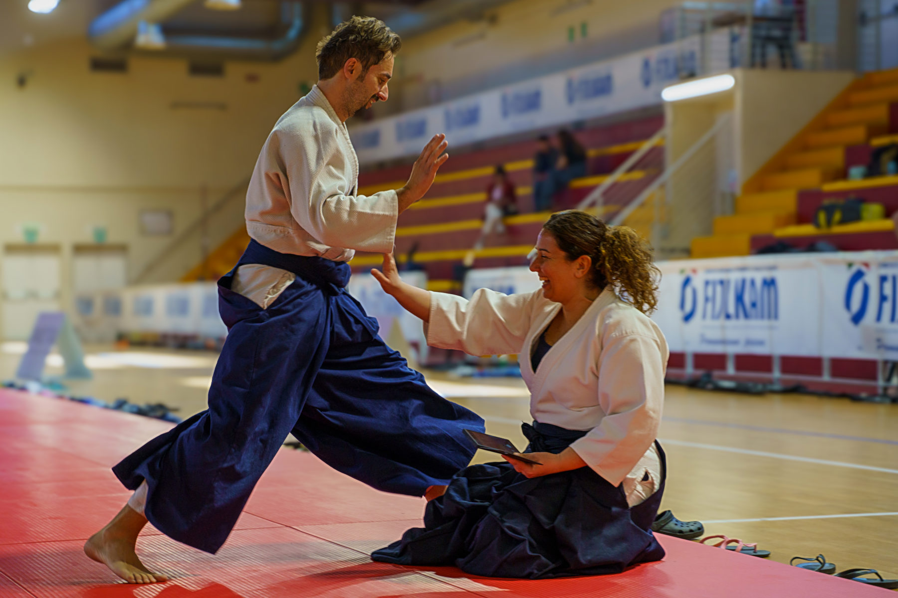 Un istruttore in hakama e una allieva durante una dimostrazione di aikido