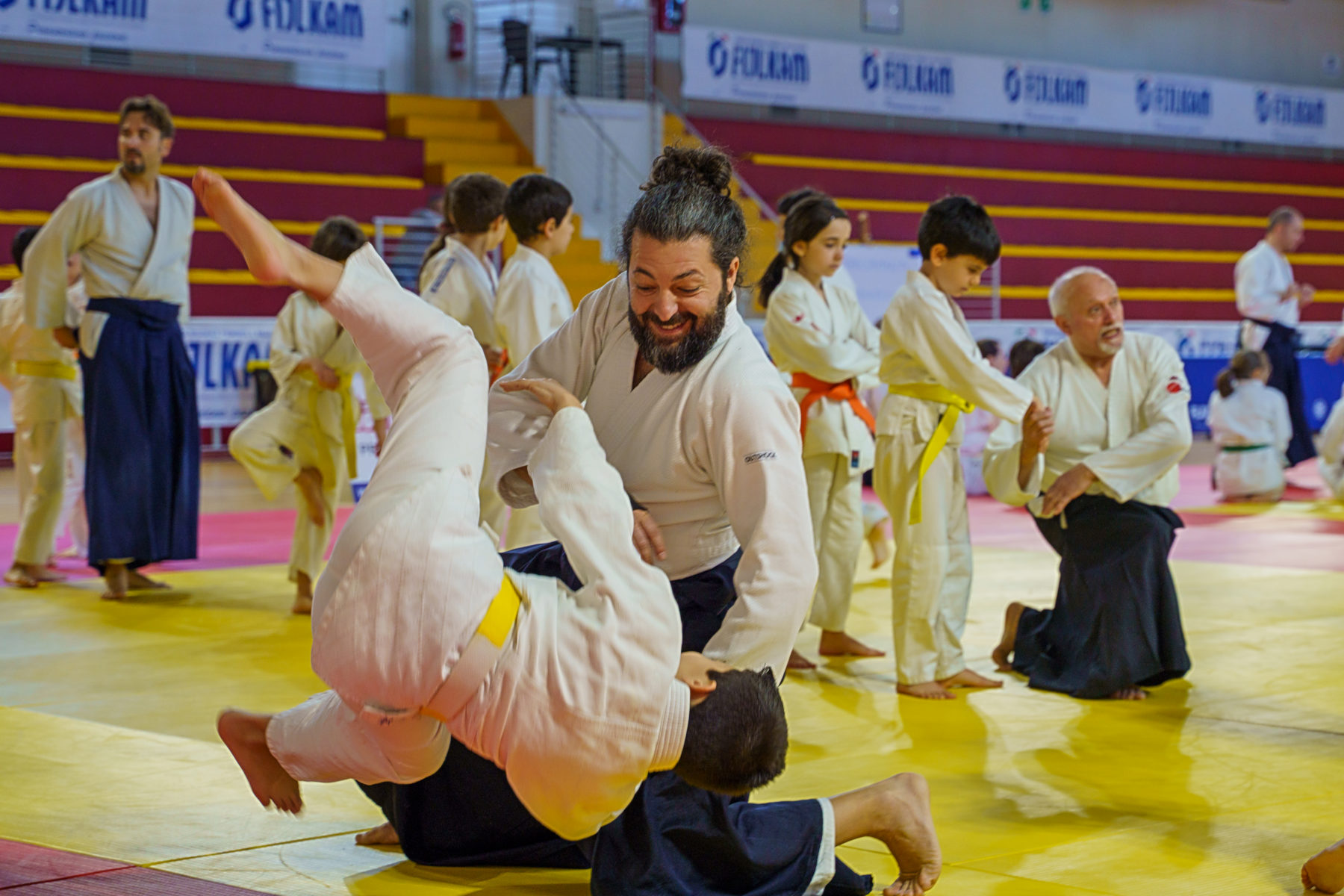 Una proiezione di aikido: il bambino è in aria sul tatami