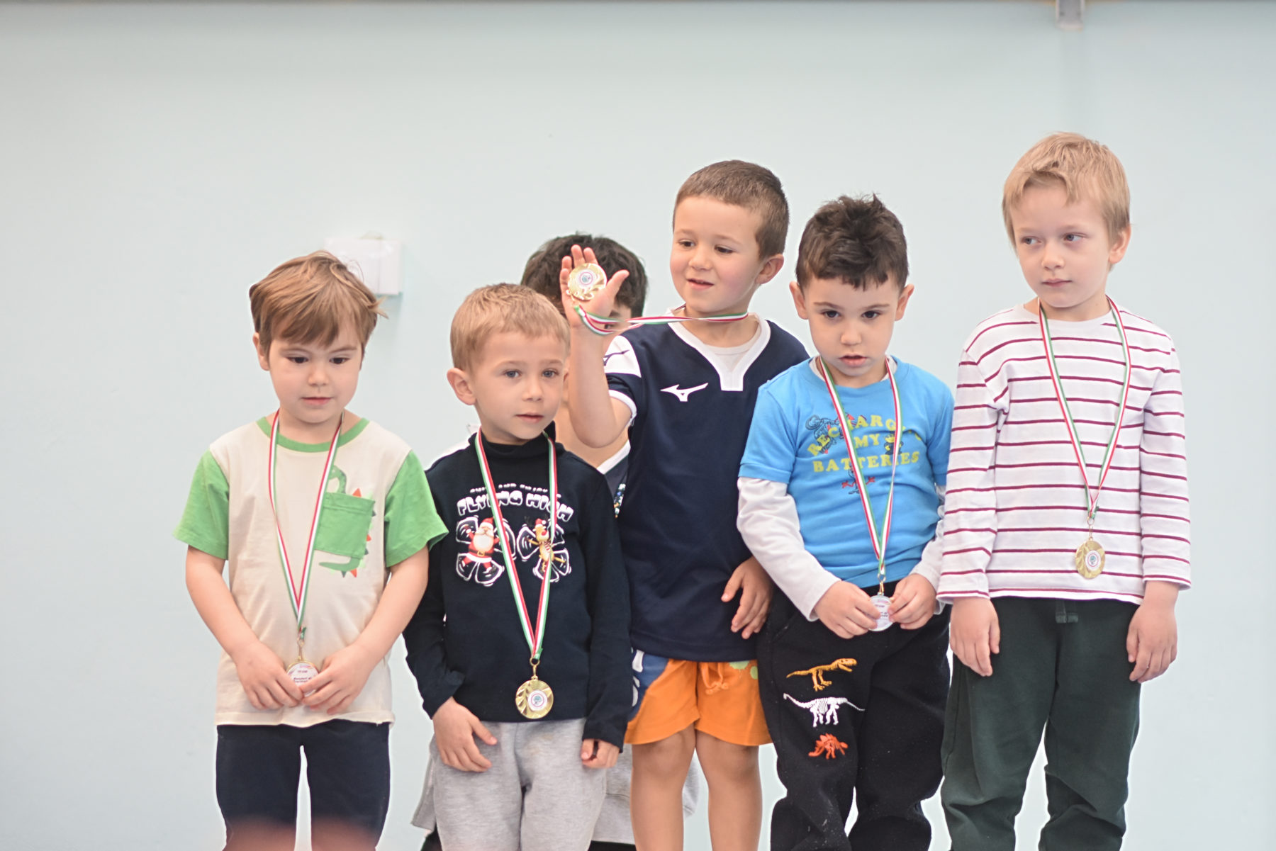 Cinque bambini piccoli in fila con la medaglia